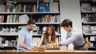 Member architects reviewing architectural model.