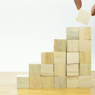 Fingers stacking blocks showing great impact