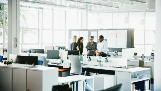 People gathering in cubicle style office