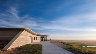 Camouflaging into the context, the building's form emulates its surroundings. Four varieties of local limestone wrap the exterior in stratified bands, emulating the layers of stone peaking from the surrounding hillsides.