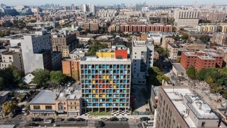 Gridded concrete façade with colorful painted steel panels stands out in