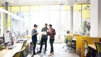 Coworkers standing in office space