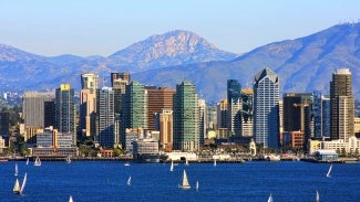 San Diego skyline from bay with mountains in background.