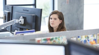 Female student at desk looking at monitor