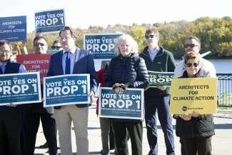 Georgi Ann Bailey holding a Architects for Climate Action sign