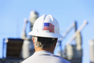 a man wears a white hard hat with an American flag sticker