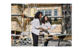 two female architects review plans on a job site