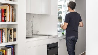 New York studio apartment featuring divider wall of Fisher & Paykel appliances.