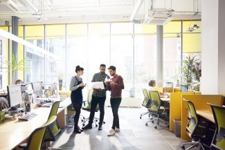 Coworkers standing in office space