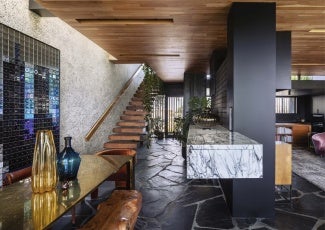 Interior of home with black floor, black column, and cedar stairs