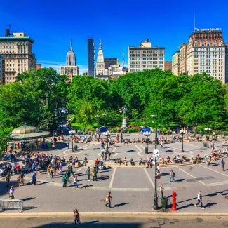 Overview of a park in New York City with hundreds of people