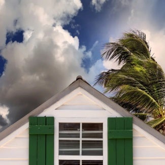 top of a house with clouds and palm trees in the background