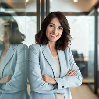 A women standing against a wall in an glass office