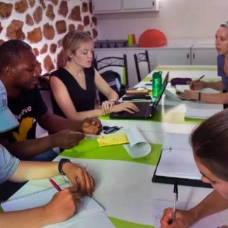 2022 Associates Award winner, Emily McGee (McGowan), Assoc. AIA, and others, discuss Zanmi Lasante O.R. suite renovations during a design charette in Cange, Haiti.