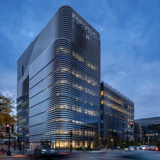 High Performance Ribbons: Folded ribbons of stainless steel define the exterior expression of EXP. This sinuous wrapper pinwheels around the building responding to both the solar exposure and the program, tapering open and closed to express varying levels of solid and transparent screening.