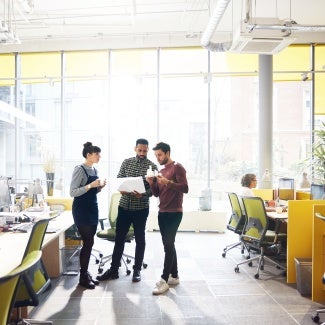 Coworkers standing in office space