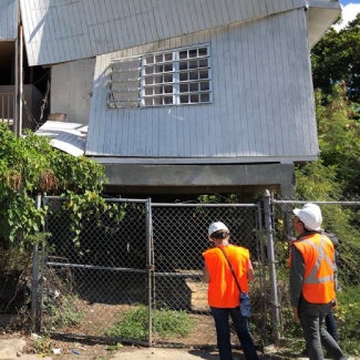 image of architects surveying a damaged house